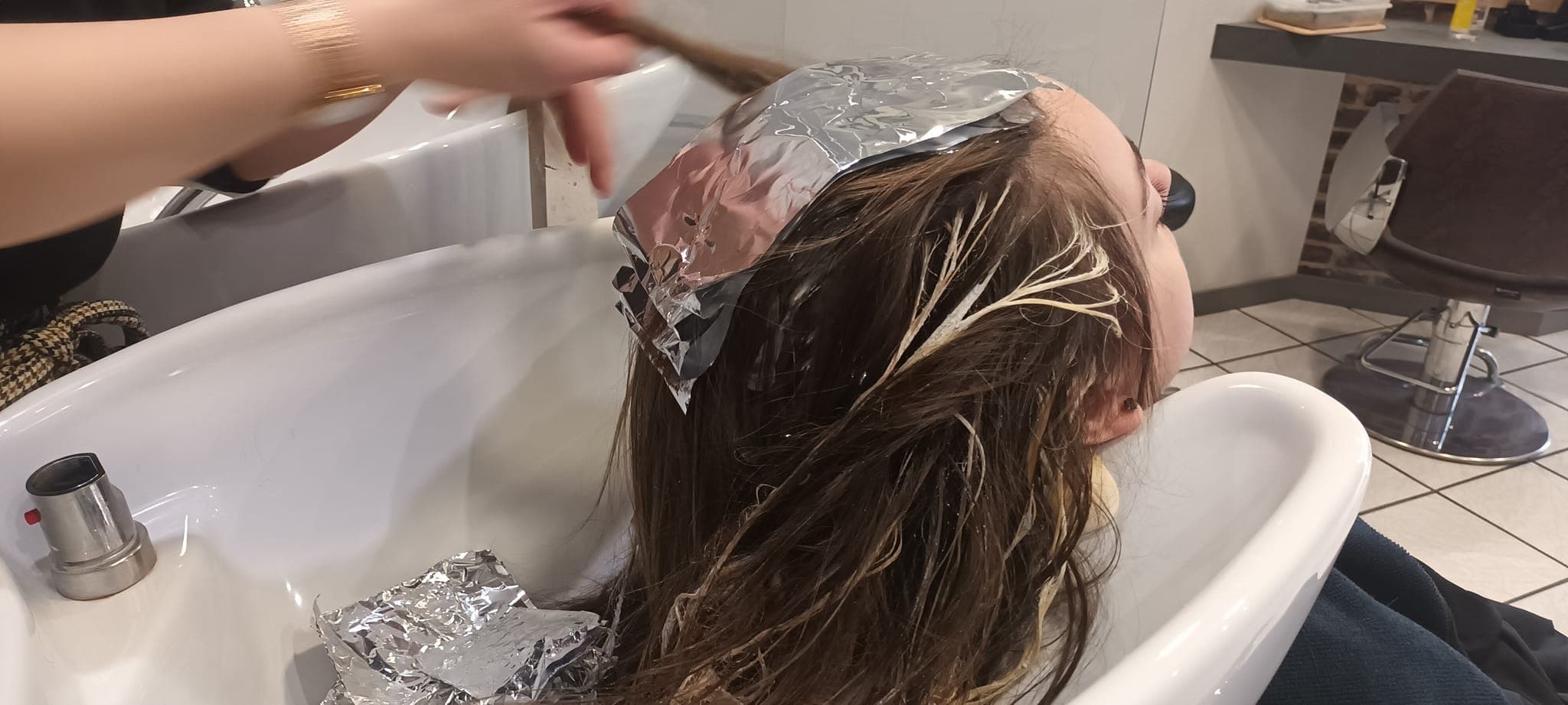 Pose de mèches au bac à shampoing dans le salon