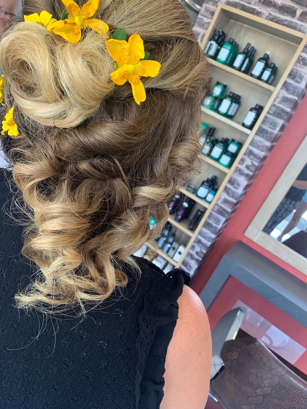 Chignon bouclé orné de fleurs jaunes, coiffure de mariage